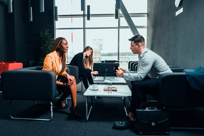The business executive lounge at Lublin Airport features seating areas with tables, providing a space for work and conversation.