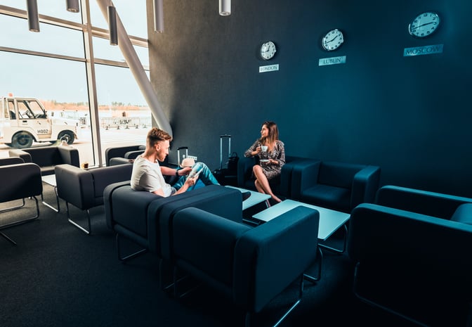 The Business Executive Lounge at Lublin Airport features comfortable seating with views of the tarmac and multiple world clocks.