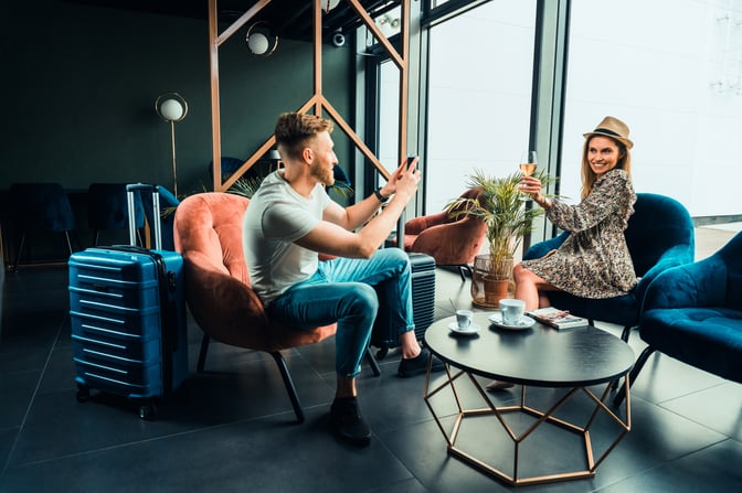Seating area in the Business Executive Lounge at Lublin Airport features comfortable chairs, a small table with coffee cups, and large windows.