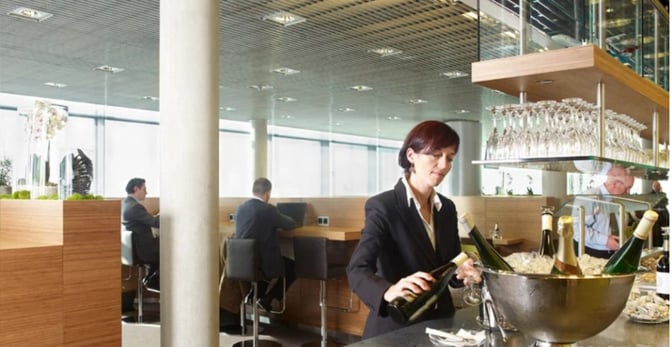 The Lounge at Luxembourg Findel Airport features a bar area with complimentary wine service and seating for travelers.