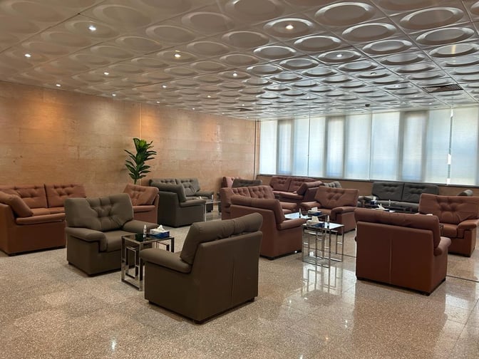 The seating area in Pearl Lounge at Luxor International Airport features multiple sofas and tables, providing a comfortable waiting space for travelers.