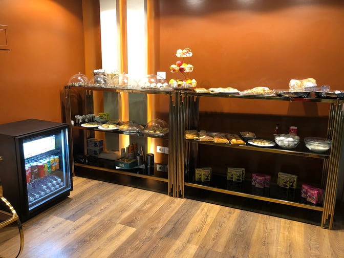 The Pearl Lounge at Luxor International Airport offers a self-serve food area with snacks, pastries, and a beverage cooler.