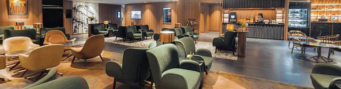 The Plaza Premium First lounge at Macau International Airport features comfortable seating and a self-serve beverage area with snacks.