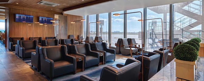 The seating area in Plaza Premium Lounge at Mactan-Cebu International Airport features armchairs with individual lamps and views of the tarmac.