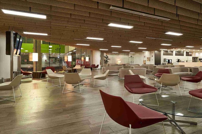 The seating area in Sala VIP T3 at Malaga Airport features modern chairs and tables with views of the terminal.