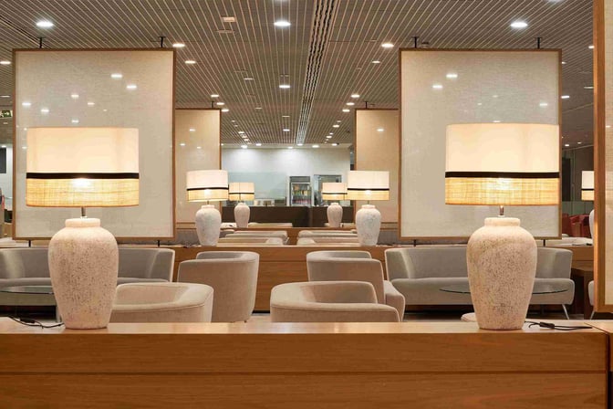 The seating area in Sala VIP T3 at Malaga Airport features comfortable chairs and tables, with decorative lamps providing ambient lighting.
