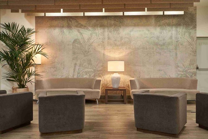 The seating area in Sala VIP T3 at Malaga Airport features comfortable chairs, sofas, and a central lamp for relaxation.