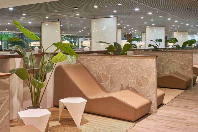 The seating area in Sala VIP T3 at Malaga Airport features lounge chairs with privacy partitions and small side tables.