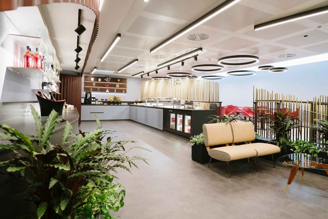 The Monteverdi Classic Lounge at Malpensa Airport features a self-serve food area with beverage options and seating arrangements.