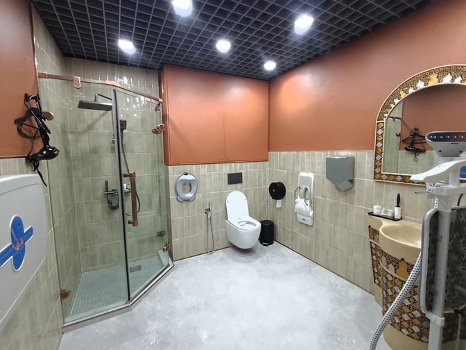 The business lounge at Manas International Airport features a private restroom with a shower, toilet, and baby changing station.