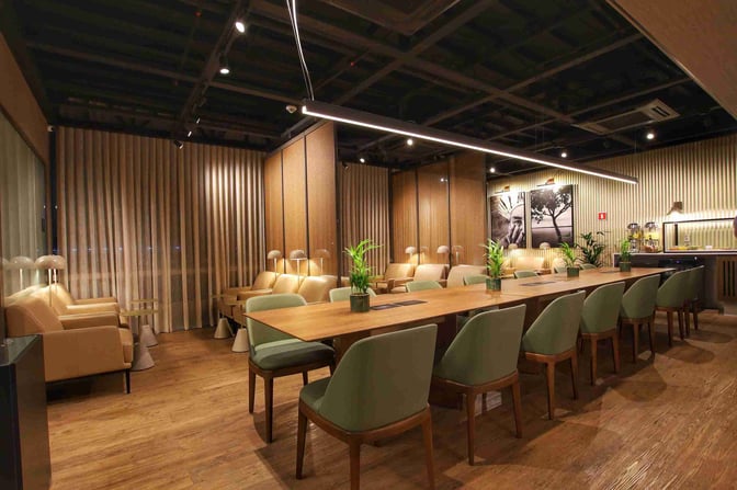 The W Lounge at Cuiabá Airport features a seating area with armchairs, a communal table, and a refreshment station.