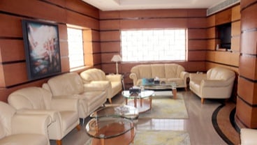 The seating area in the Pearl Lounge at Marsa Alam International Airport features comfortable chairs and glass tables for relaxation.