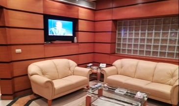 The seating area in the Pearl Lounge at Marsa Alam International Airport features comfortable sofas and a wall-mounted television.
