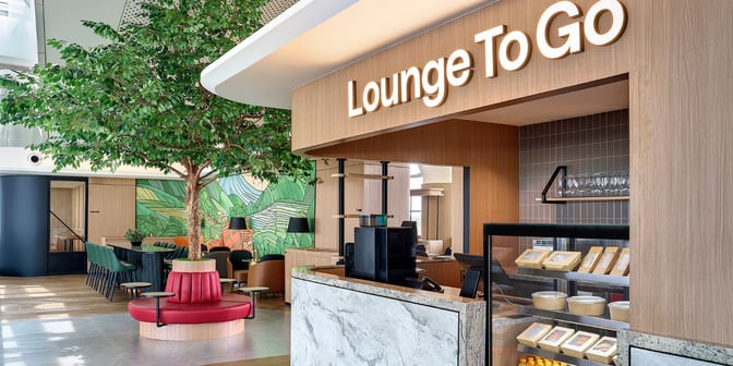 The Plaza Premium Lounge at Kualanamu International Airport features a "Lounge To Go" counter with packaged food and a seating area.