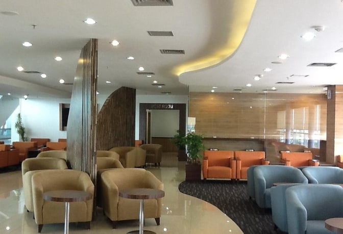 The Saphire Lounge at Kualanamu International Airport features a seating area with armchairs and small tables for passenger relaxation.