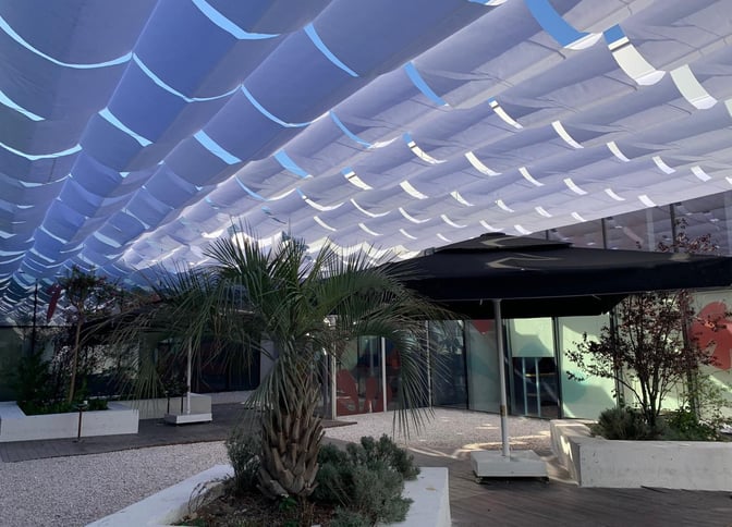 The outdoor area of Primeclass Lounge at Milas–Bodrum Airport features shaded seating with plants and decorative elements.