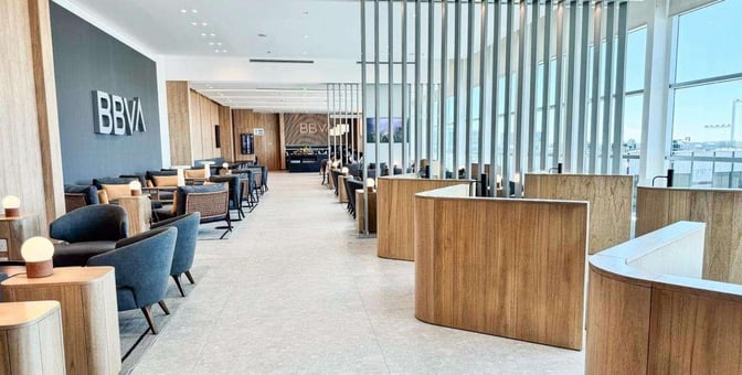 The BBVA Lounge at Ministro Pistarini International Airport features comfortable seating areas with tables and a view of the tarmac.