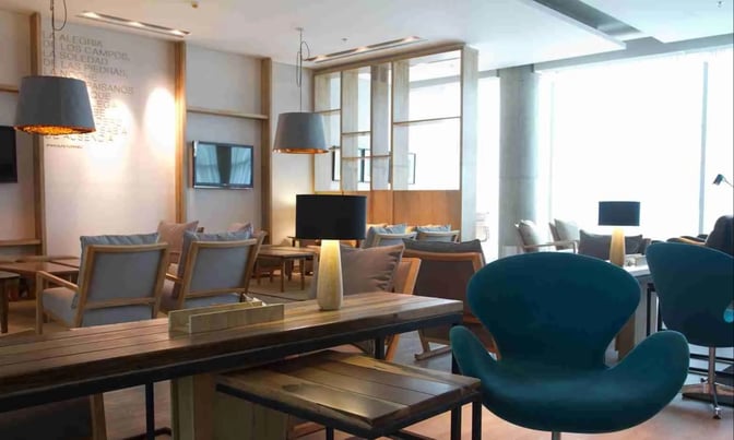The seating area in the Star Alliance Lounge Buenos Aires features comfortable chairs and tables with individual lamps for travelers.