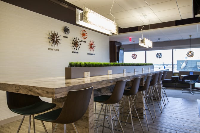 The Escape Lounge at Minneapolis-Saint Paul International Airport features a long counter with bar seating and power outlets.