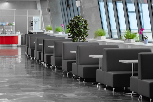 Booth seating in the Domestic Business Lounge at Minsk National Airport offers semi-private tables with views through large windows.