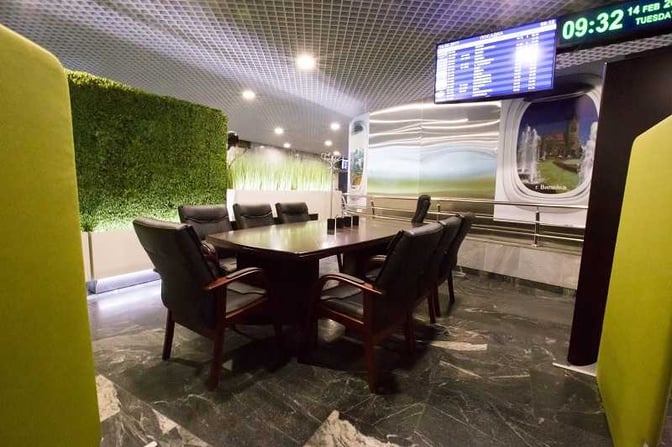 The International Business Lounge at Minsk National Airport features a conference table with seating and a flight information display.