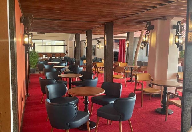 The Bosphorus Lounge at Moi International Airport features a seating area with round tables and chairs for travelers to relax.
