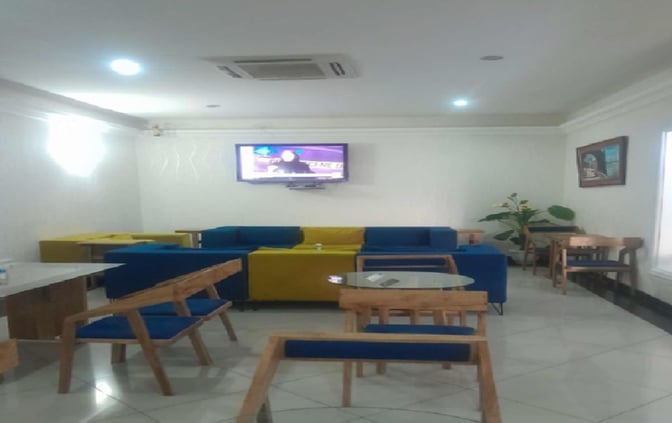 The Safari Comfort Lounge at Moi International Airport features seating with a wall-mounted TV and tables for guest use.