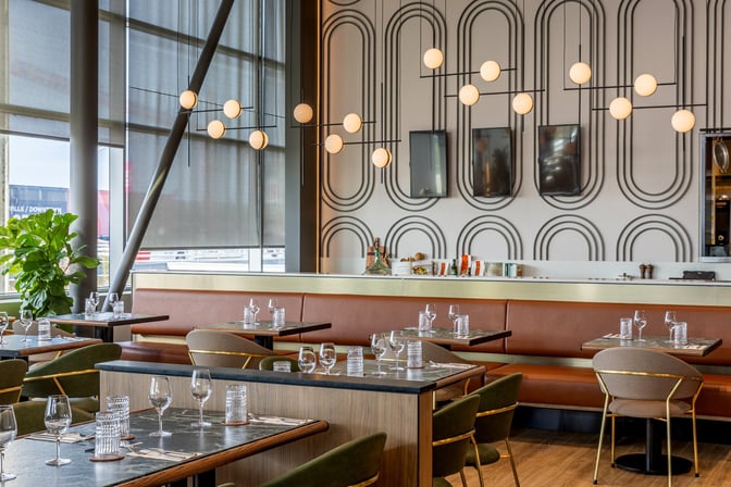 The Aspire Lounge at Montreal-Trudeau International Airport features a dining area with table seating and set tables for guests.