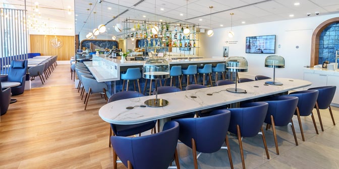 The Air France Lounge at Montreal-Trudeau Airport features a bar with high stools and a communal table with charging ports.