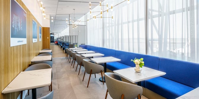 The Air France Lounge at Montreal-Trudeau International Airport features a seating area with tables and chairs for dining and relaxation.
