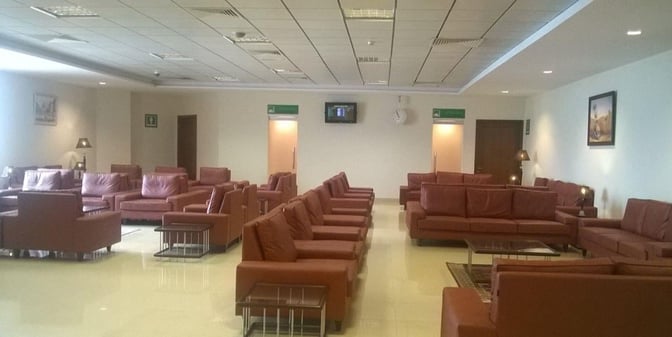 The CIP Lounge at Multan International Airport features multiple seating areas with armchairs and sofas, providing a comfortable waiting space.