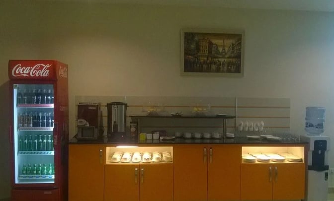 The CIP Lounge at Multan International Airport features a self-serve beverage station with a refrigerator, coffee machine, and water dispenser.