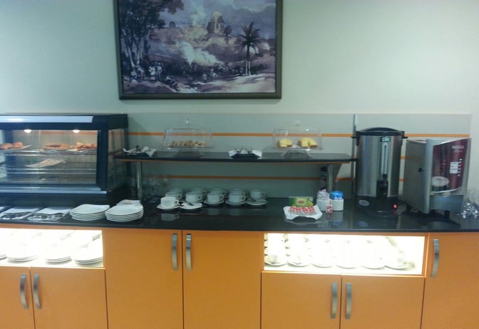 Self-serve food and beverage station at CIP Lounge, Multan International Airport, offers pastries, hot drinks, and tableware for guests.
