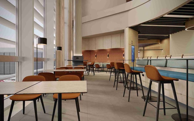 The seating area at Airport Lounge World, Munich Airport, features tables and high stools, offering views of the tarmac through large windows.