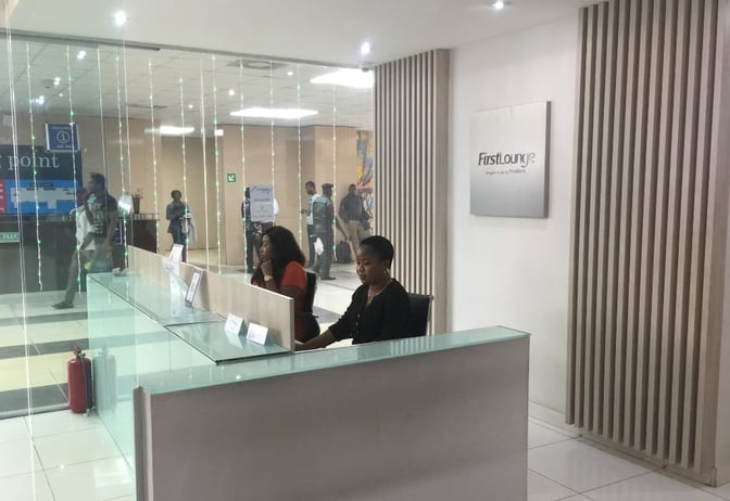 The First Lounge reception at Murtala Muhammed International Airport features a check-in desk with staff ready to assist travelers.