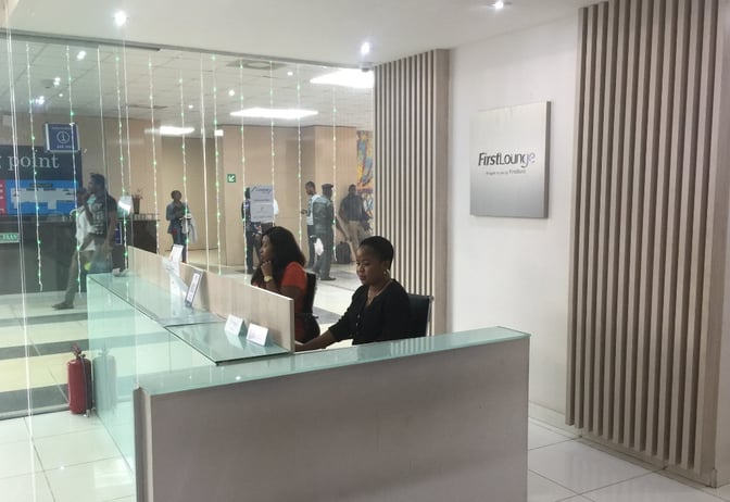 The First Lounge reception at Murtala Muhammed International Airport features a check-in desk with staff ready to assist travelers.