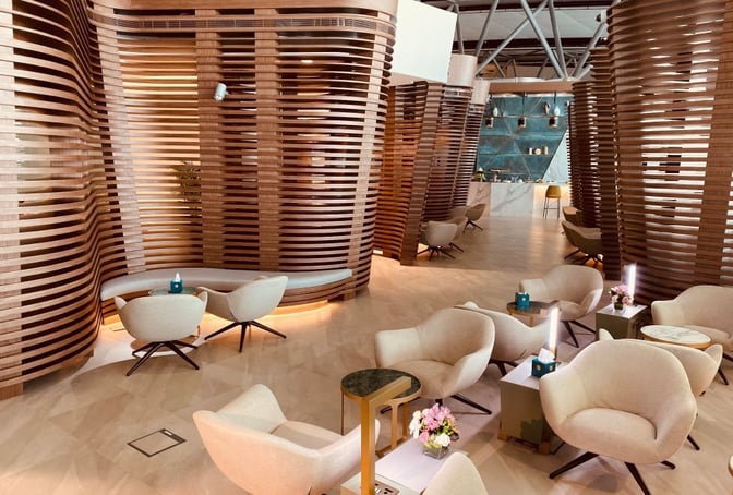 The seating area in Majan Lounge at Muscat International Airport features comfortable chairs and tables, offering a relaxing space for travelers.