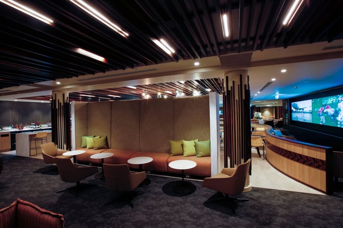 The Fiji Airways Premier Lounge at Nadi International Airport features a seating area with cushioned chairs and tables for relaxation.