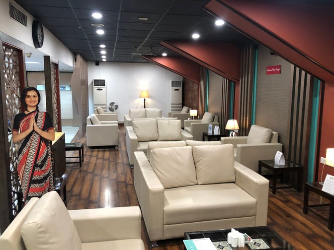 The seating area at Mandarin Lounge, Dr. Babasaheb Ambedkar International Airport, features comfortable chairs and tables with ambient lighting.