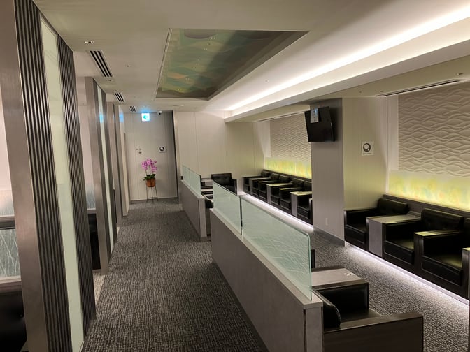The seating area at Lounge RYURIN in Naha Airport features individual armchairs and small tables, providing a comfortable waiting space.