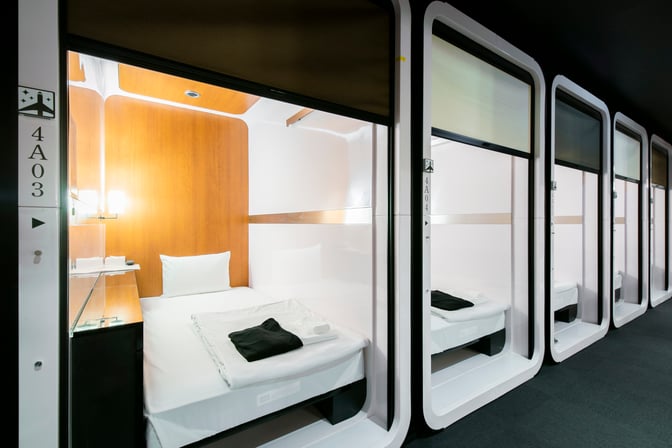The First Cabin Naha Airport lounge features compact sleeping pods with beds and basic amenities for travelers seeking rest.
