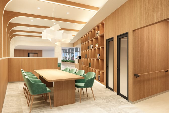 The First Cabin Naha Airport lounge features a communal table with seating and a wall of shelves for reading materials.