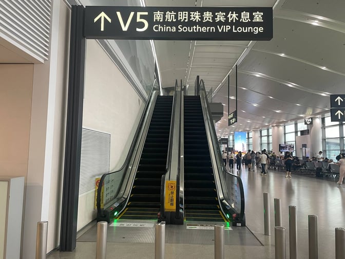The entrance to the China Southern VIP Lounge at Nanjing Lukou International Airport is accessed via an escalator near Gate 115.