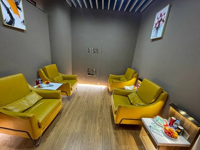 The seating area in the China Southern Airlines lounge at Nanjing Lukou International Airport features armchairs and side tables with refreshments.