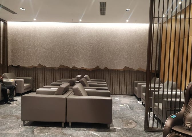 The V9 Business Lounge at Nanjing Lukou International Airport features a seating area with rows of cushioned chairs for travelers.