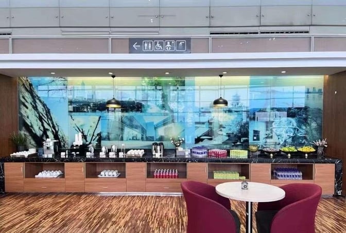 The V6 Business Lounge at Nanjing Lukou International Airport features a self-serve refreshment area with snacks, beverages, and seating.