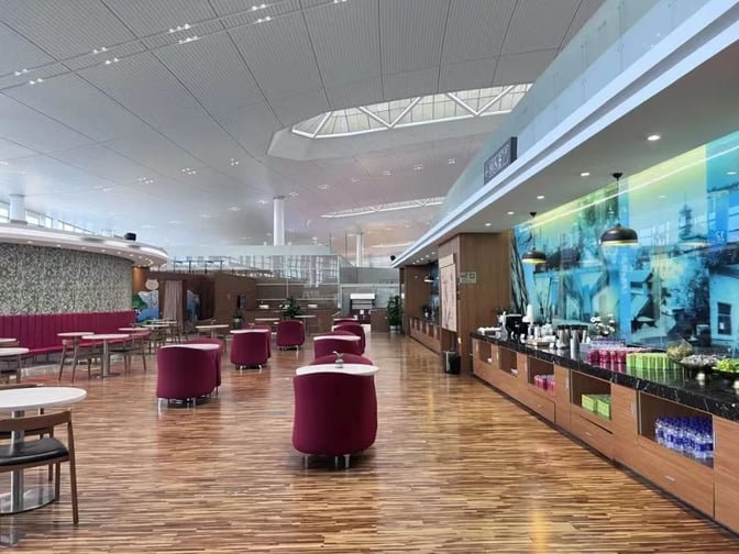 The V6 Business Lounge at Nanjing Lukou International Airport features a self-serve beverage station and various seating options for travelers.