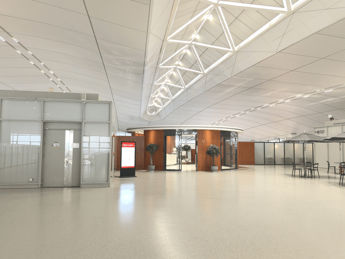 The entrance to the V7 International First Class Lounge at Nanjing Lukou International Airport features a circular design with potted plants.