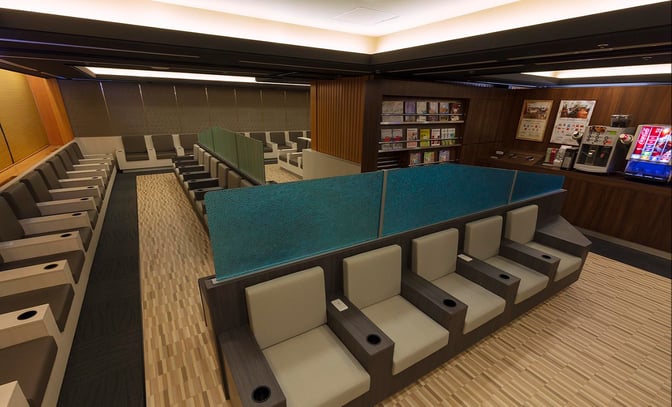 The IASS Executive Lounge 1 at Narita International Airport features individual seating with armrests and cup holders, alongside a self-serve beverage station.