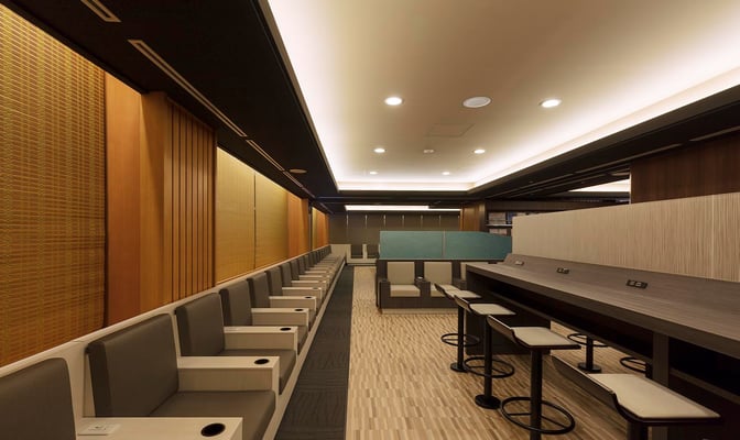 The IASS Executive Lounge 1 at Narita International Airport features a seating area with individual chairs and a counter with bar stools.